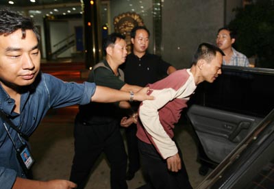Police load Zeng into car